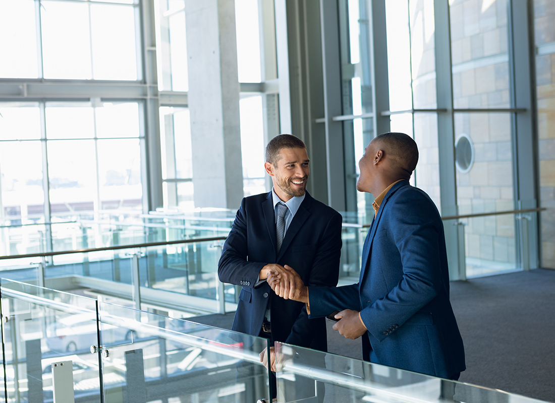 About Our Agency - Two Business Professionals Shaking Hands in a Lobby